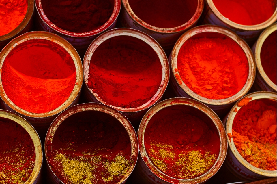 Several shades of red powders in buckets