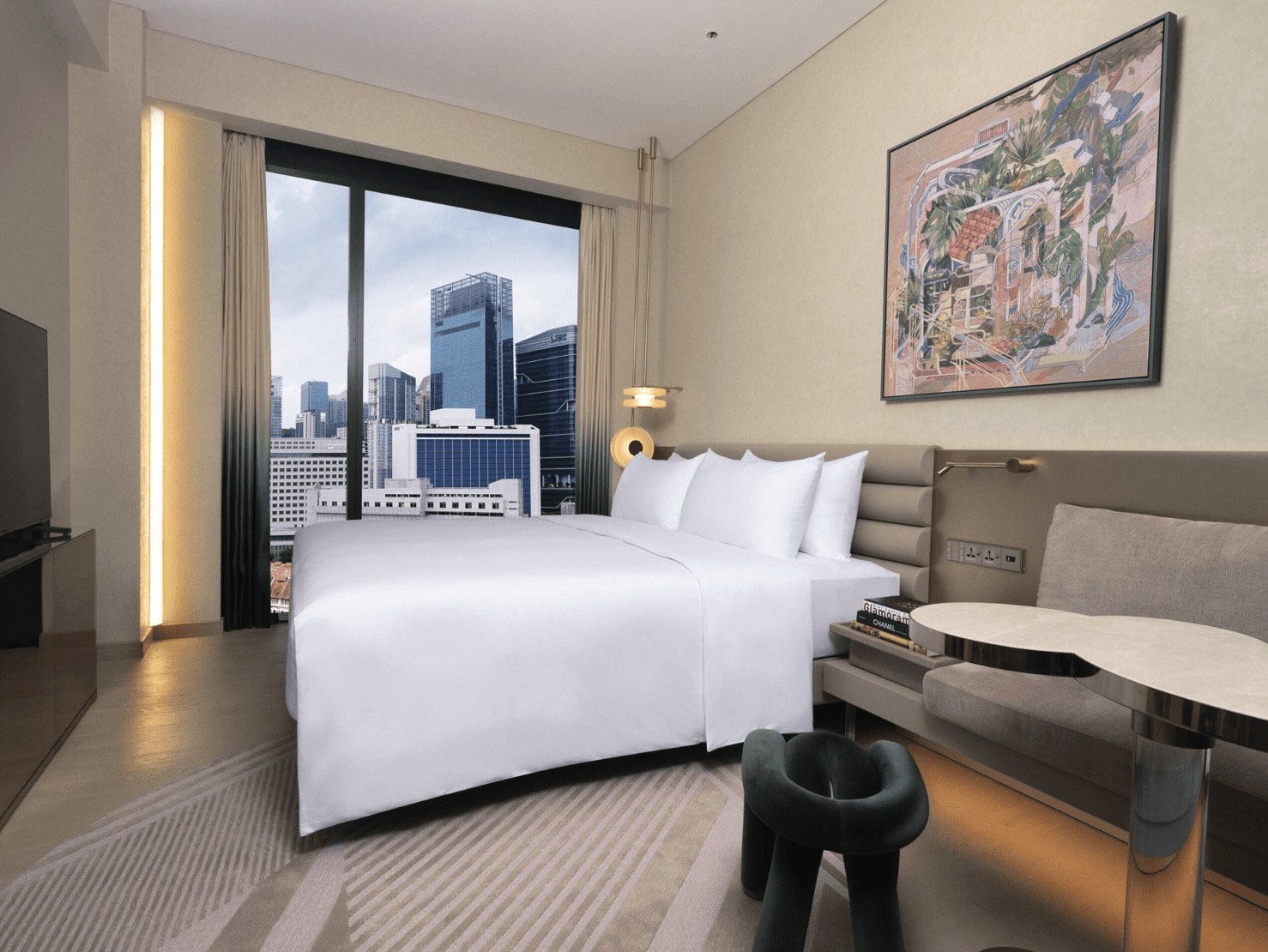 Large white bed with skyline views in the window