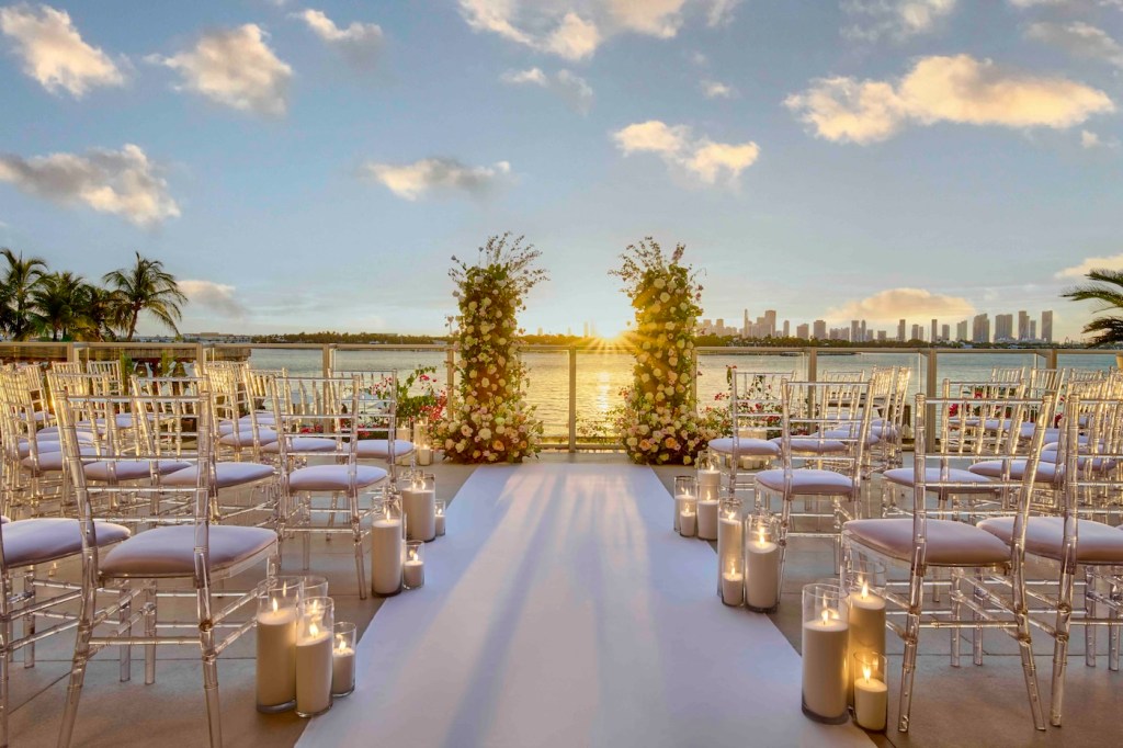 Outdoor wedding set up with white aisle and floral arrangement