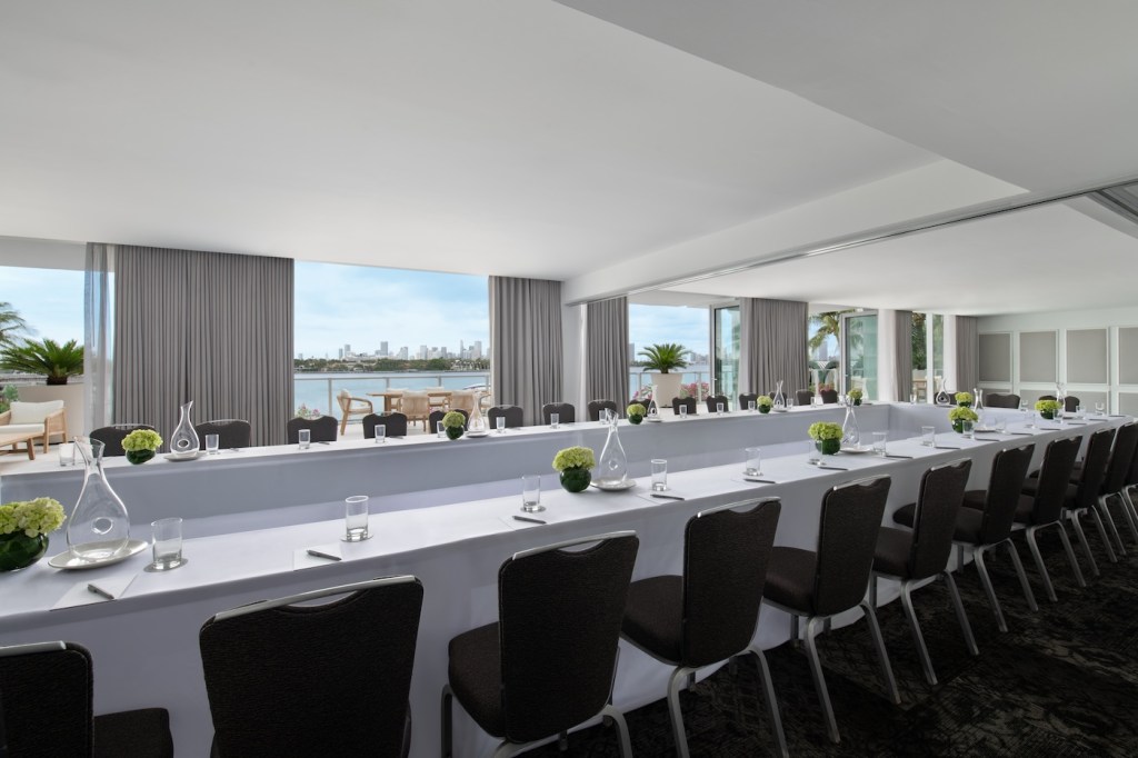 Large white event table with dark chairs