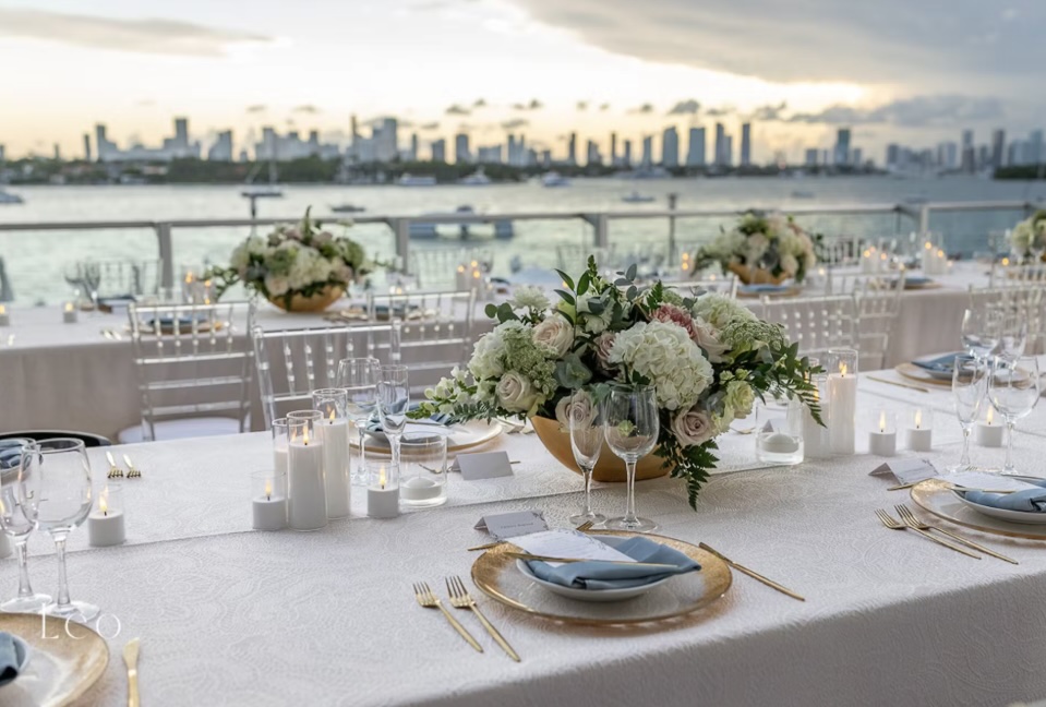White table with floral centerpiece and gold table settings