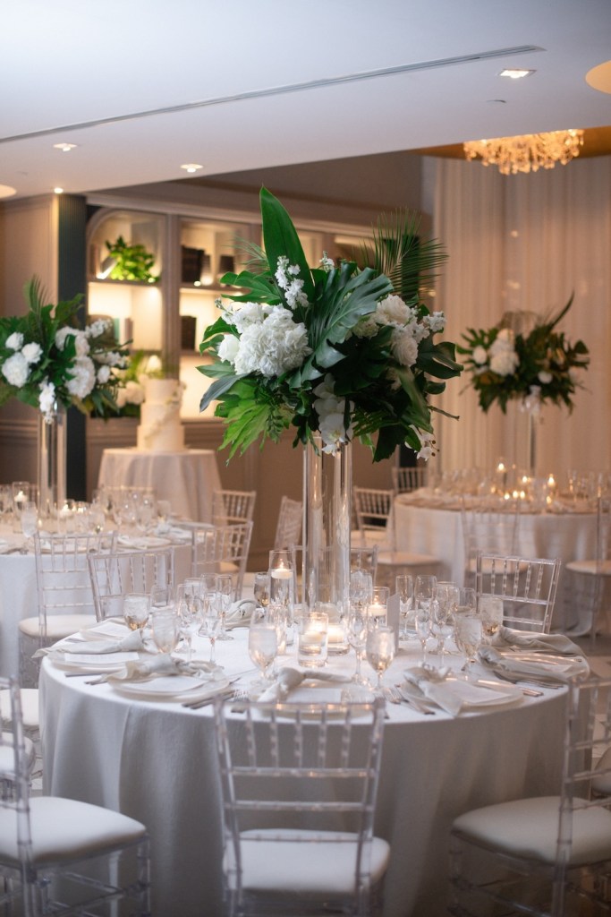 Formal event table set up with white tablecloths and floral centerpieces
