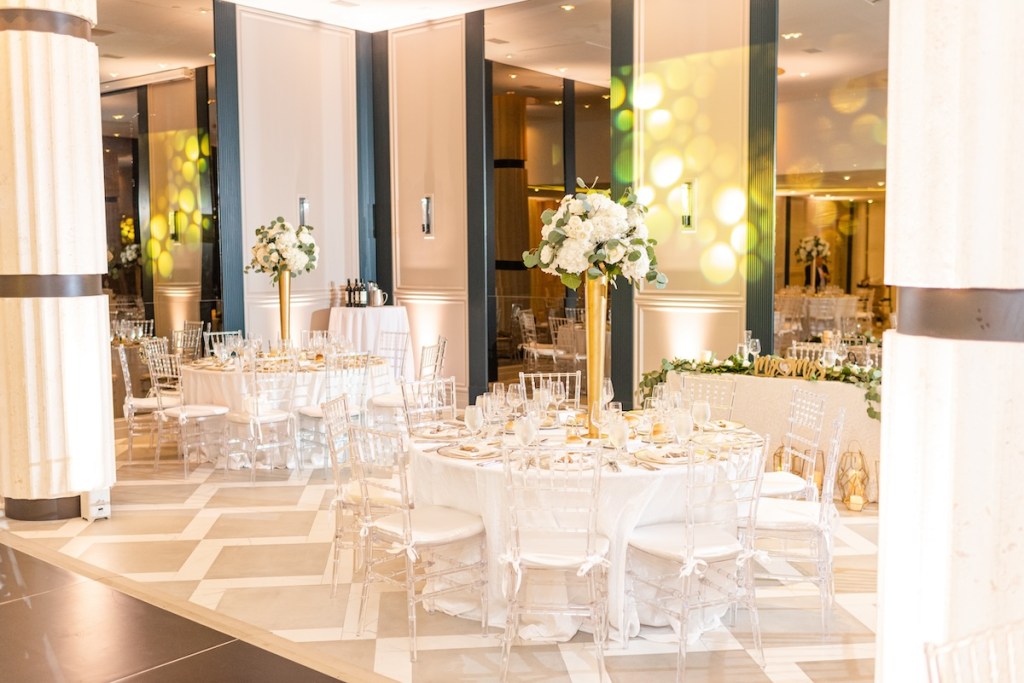 Brightly lit ballroom set for a wedding