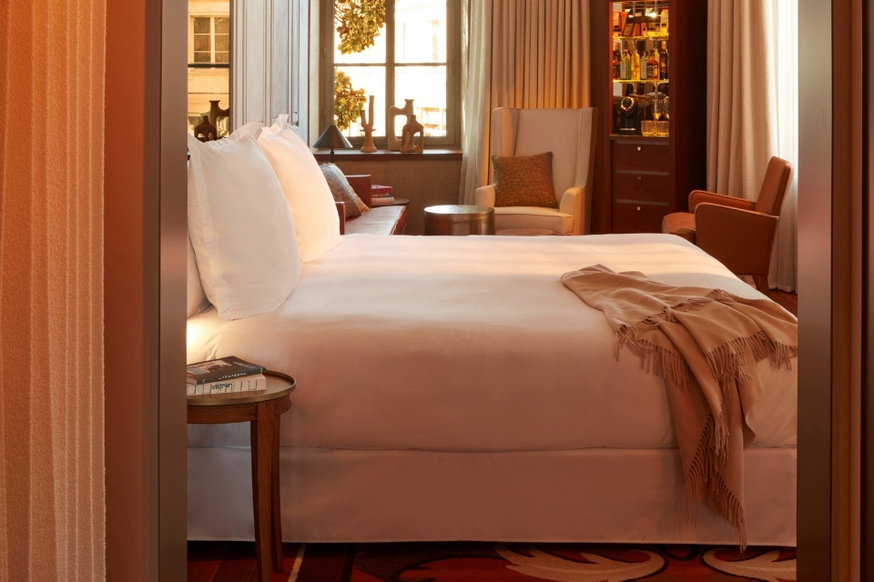 Warmly lit bedroom with large white bed