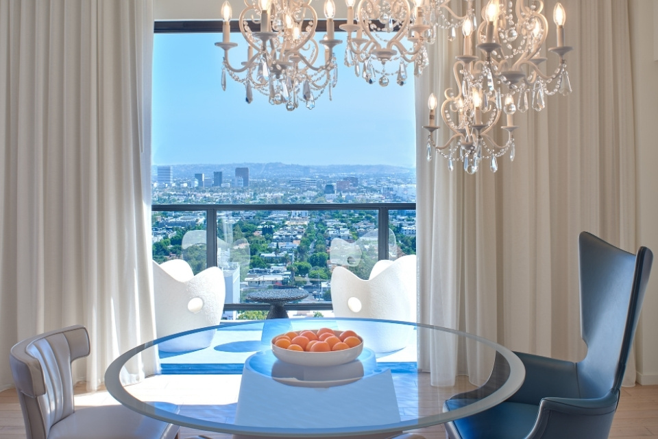 glass table with oranges and chandelier