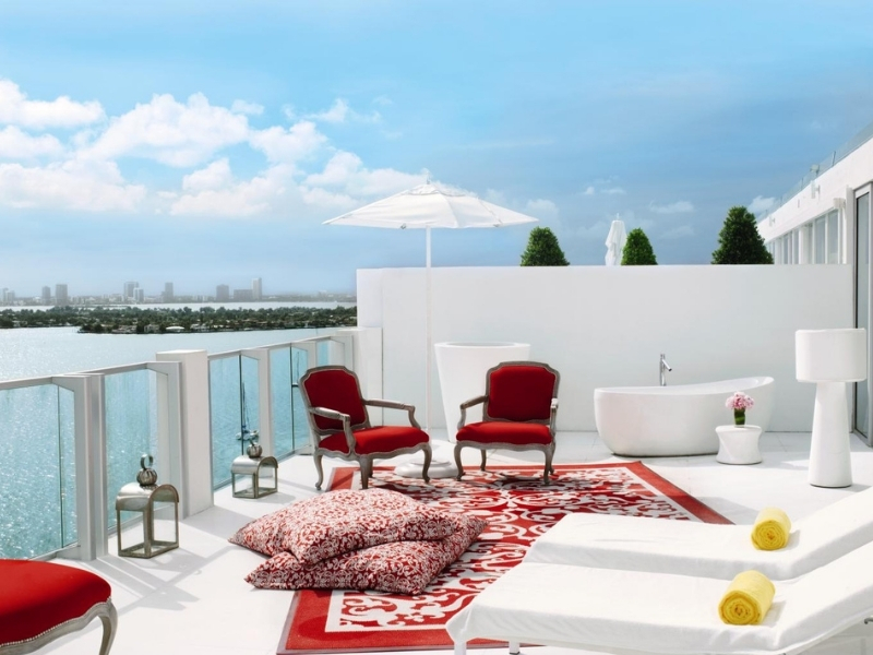 Balcony with chaise lounges and red chairs