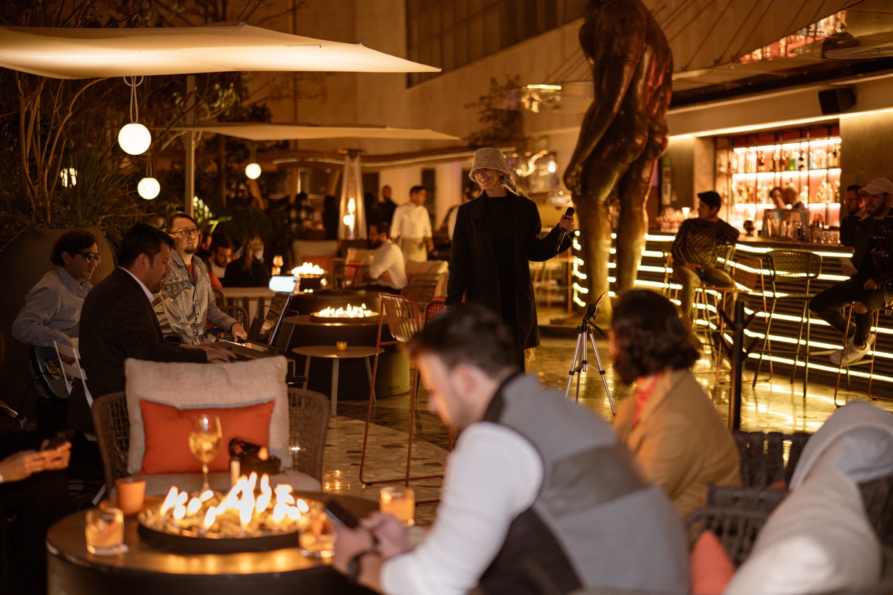 Guests enjoying an evening at La Terraza by Mondrian with live music, fire pits, cocktails, and a warmly lit outdoor bar.